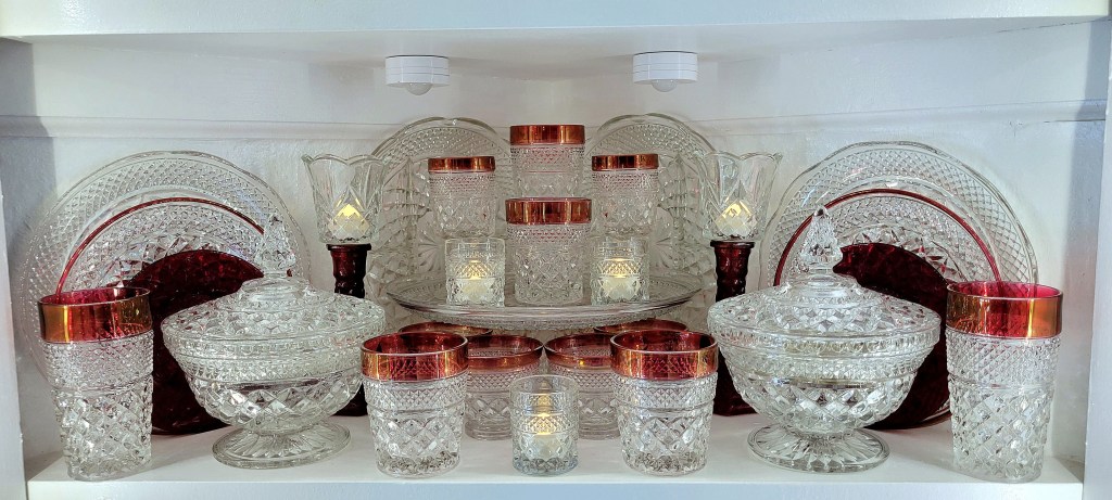 an assortment of ruby-banded glassware, ruby flashed candlesticks, and various clear glass pieces from the Anchor Hocking Wexford line, as well as royal ruby dessert plates, also from AH.