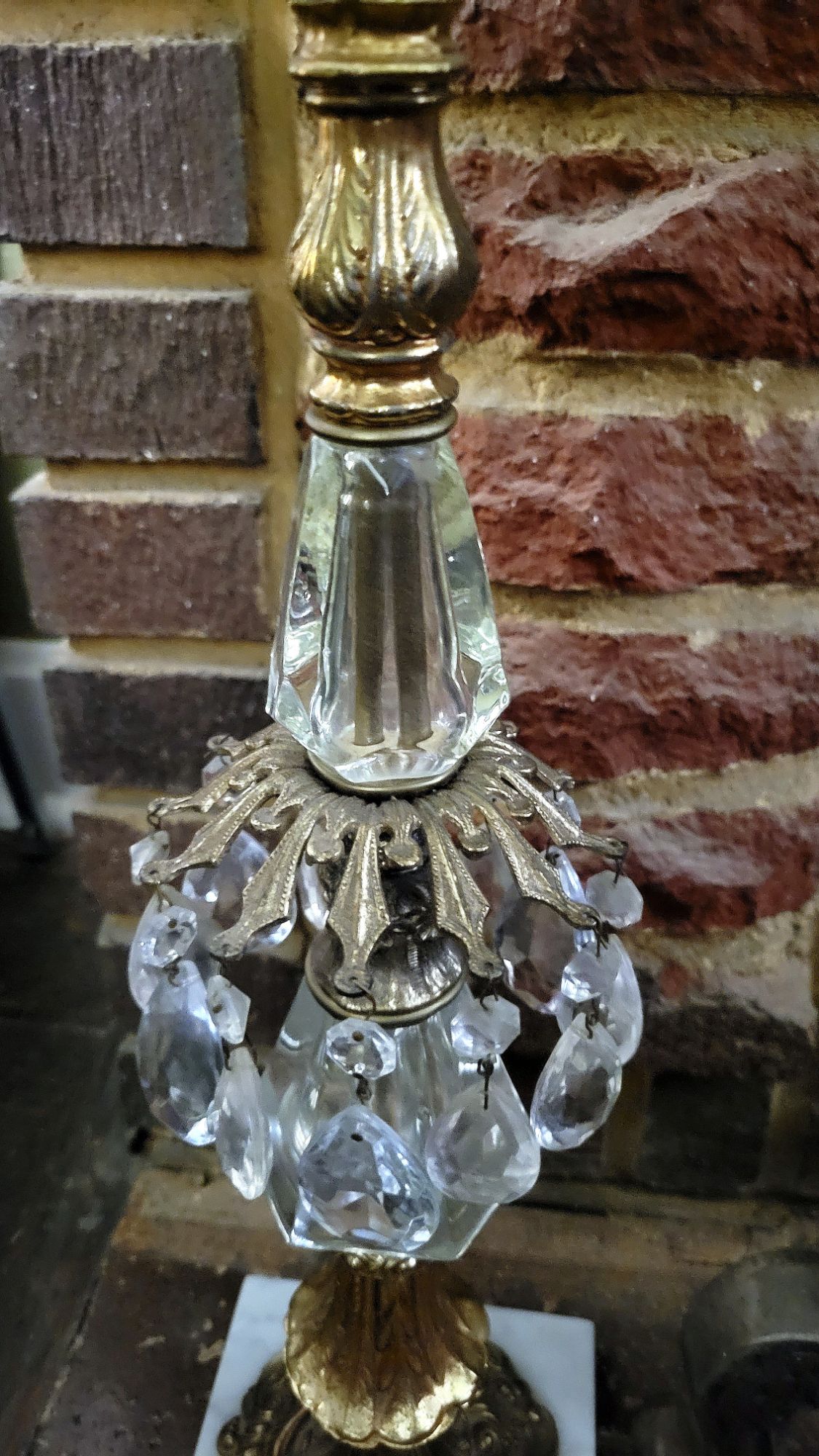 a detailed view of a Hollywood Regency-style ashtray stand, showing details of the faceted glass segments and crystal chandelier baubles. 