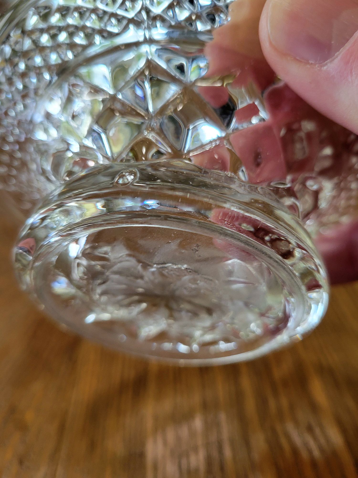 a close-up view of a pressed glass basket base, mimicking Wexford by Anchor, showing the details of the bottom edge.