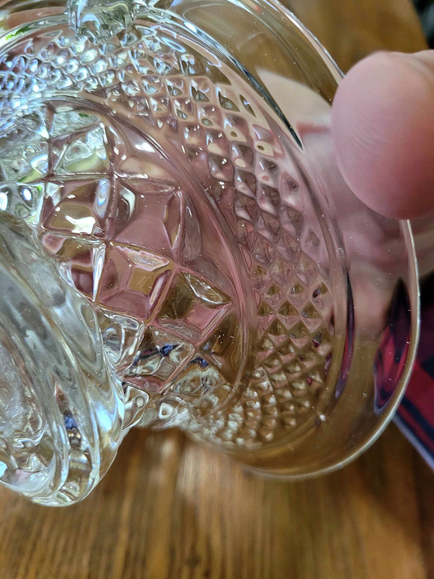 a close-up view of a pressed glass basket base, mimicking Wexford by Anchor Hocking, showing both diamond patterns.