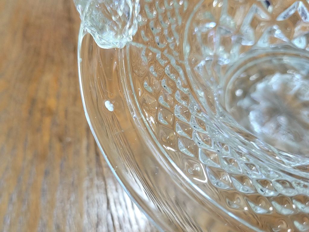a close-up view of a pressed glass basket base, mimicking Wexford by Anchor, showing a flaw in the glass.