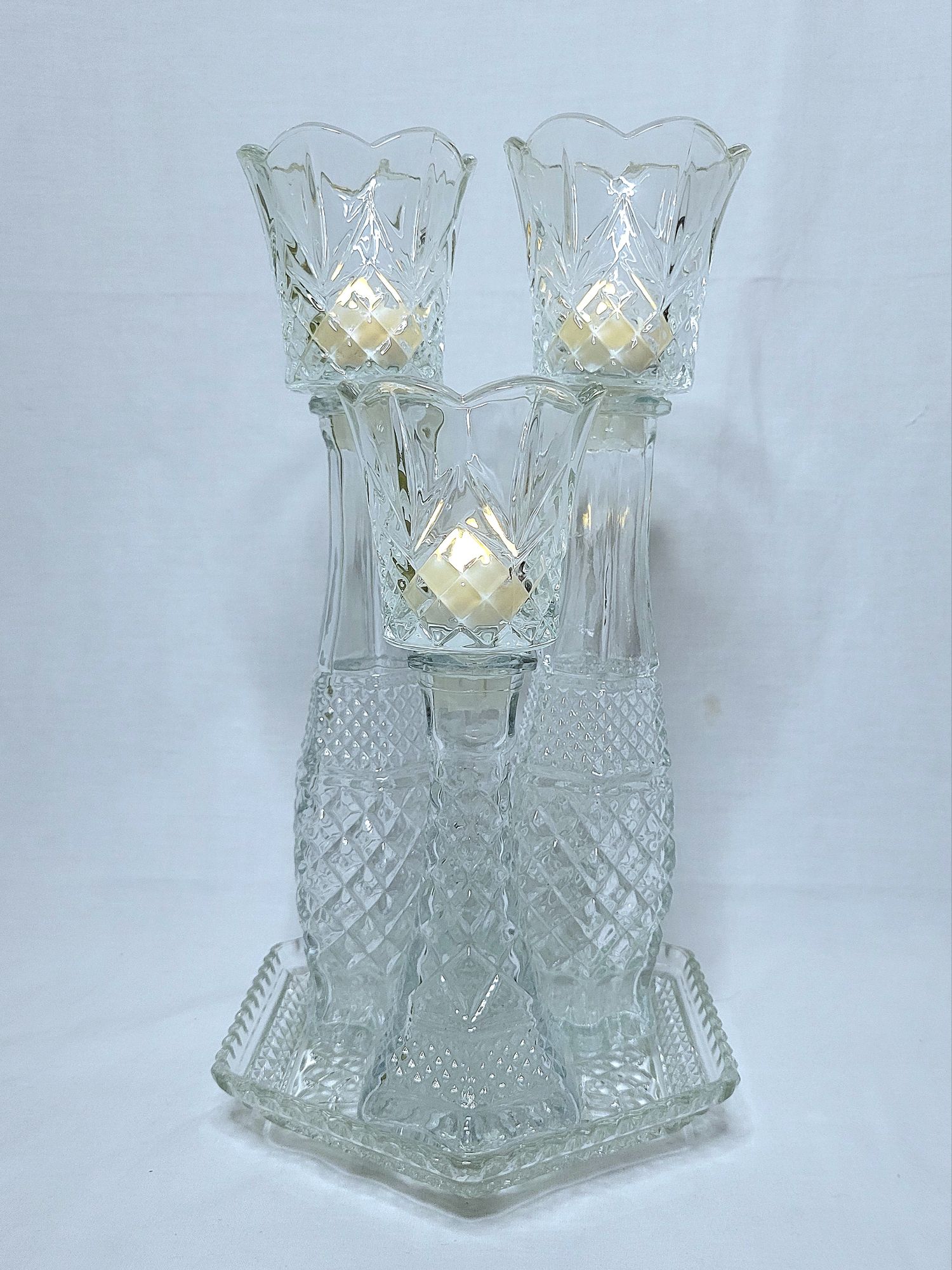 a grouping of Wexford vintage glassware by Anchor Hocking: a hexagonal plate with a mix of bud vases and peg votives with LED tealights.