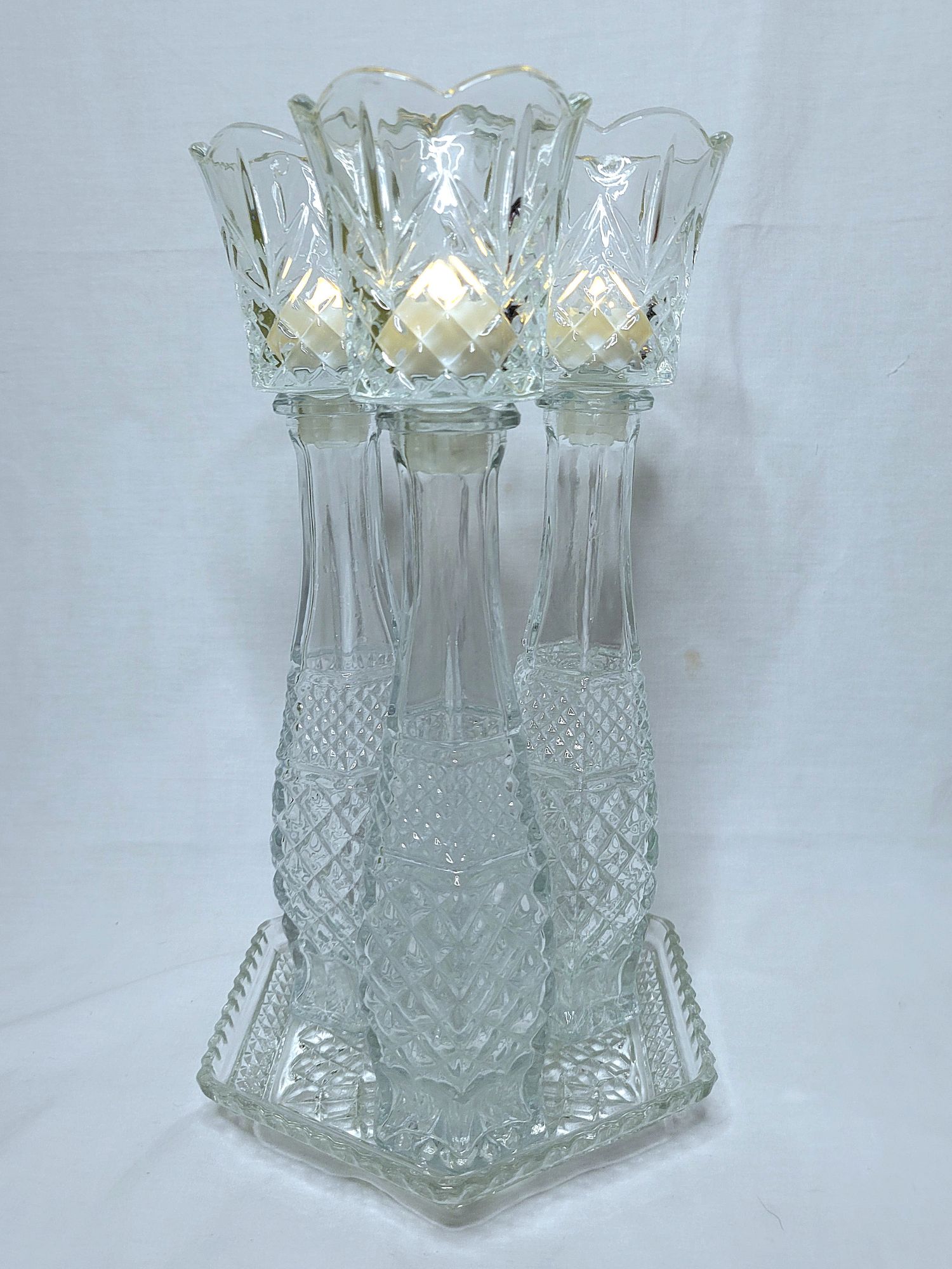 a grouping of Wexford vintage glassware by Anchor Hocking: a hexagonal plate with bud vases and peg votives with LED tealights.
