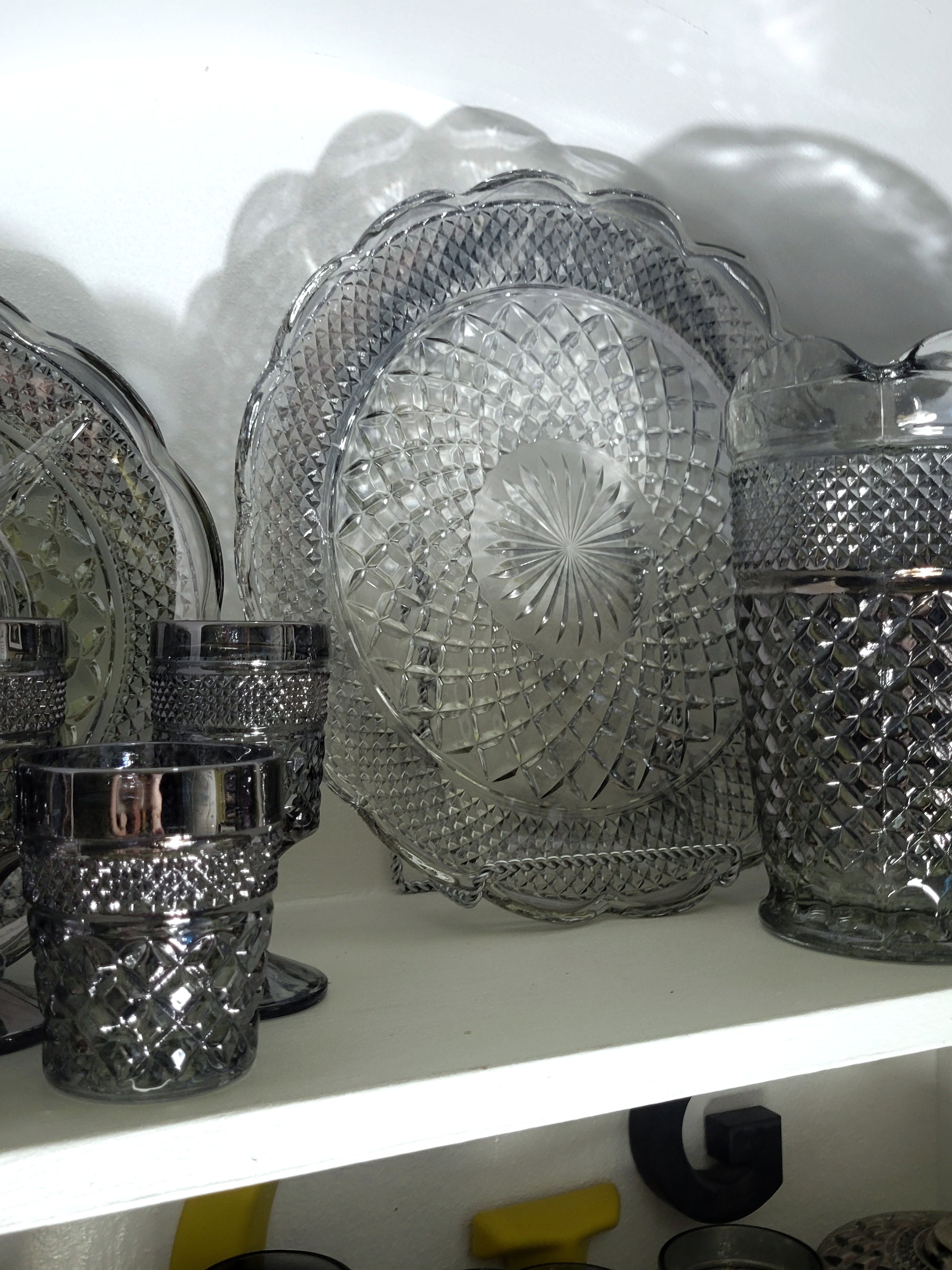 a grouping of Wexford by Anchor Hocking in the color/finish they called Pewter Mist. In the center of the grouping is my original larger platter. The color is greatly faded and the iridescence remaining mostly only on the outer perimeter.