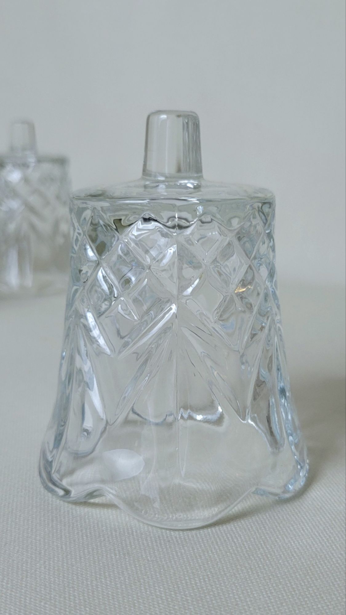 a close-up of one upside-down Cambridge peg votive by HOMCO. the pattern involves a pineapple-like diamond grid capped by a frond-like grouping.
